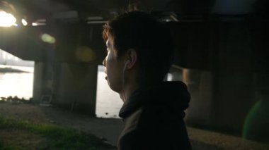 Güzel güneş ışığı Köprüsü'nün altında çalışan genç Japon adam 