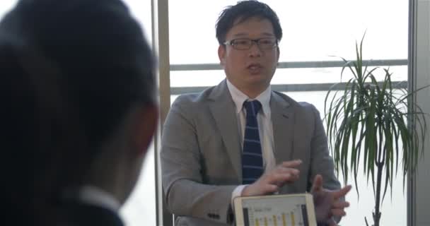 Japanse baas maken van een presentatie aan klanten over welke het bedrijf diensten kan bieden — Stockvideo