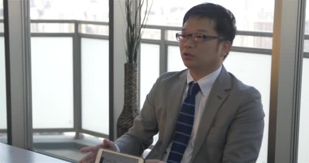 Japonské obchodní muž vysvětluje obchodní koncepty kolegům — Stock video