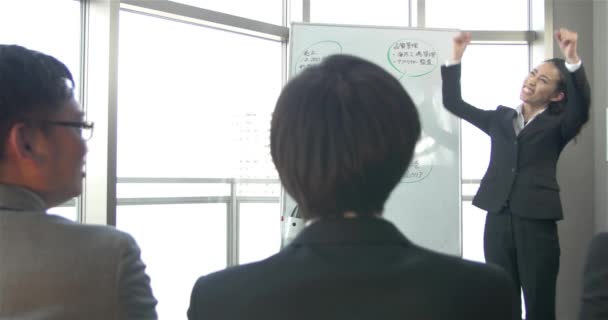 Mulheres de negócios japonesas bombeiam a equipe antes de uma grande reunião de vendas 4K — Vídeo de Stock