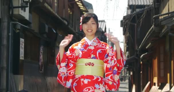 Hermosa chica japonesa en Kimono Ondas a la cámara desde Kyoto — Vídeo de stock