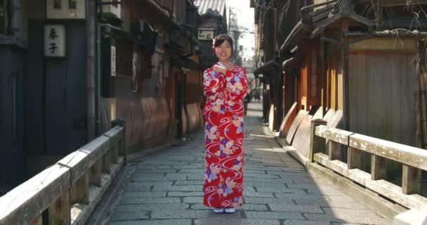 Hermosa chica japonesa en Kimono le da la bienvenida a Kioto tiro ancho — Vídeos de Stock