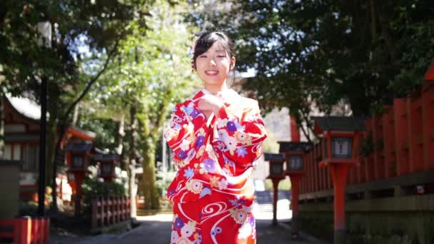 Attractive young Japanese girl wearing kimono welcomes you to Kyoto slow motion — Stock Video