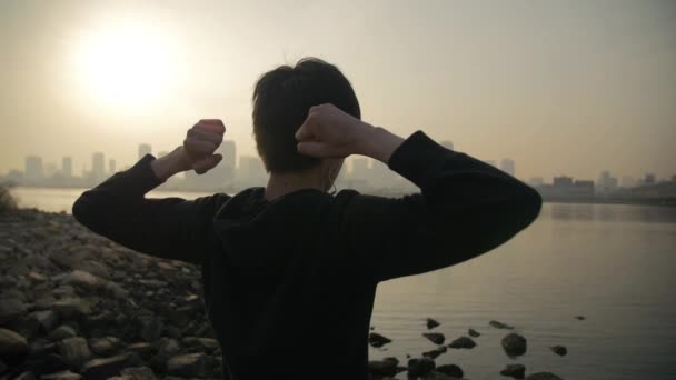 Japanaese runner stretching at sunrise overlooking the Osaka Skyline — Stock Video