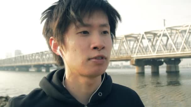 在当地的公园保持健身的日本男选手跑近摄镜头 — 图库视频影像