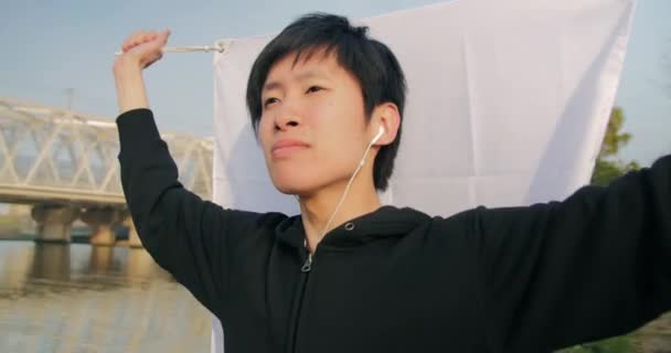 Young Japanese man holding his countries flag looking proud and pumped up 4K — Stock Video