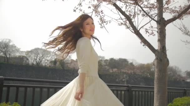 Young Japanese women spins and smiles in front of Osaka Castle background Slow motion — Stock Video