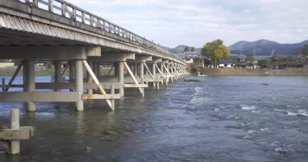 Bridge crossing arashiyama in Kyoto, Japan – stockvideo