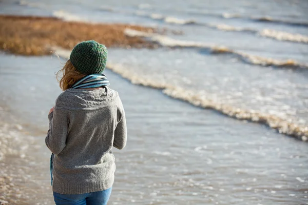 Frau geht am Strand spazieren — Stockfoto