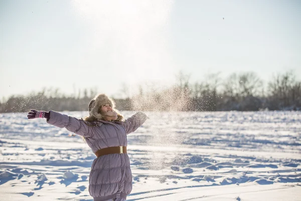 Flicka kastar snö upp — Stockfoto