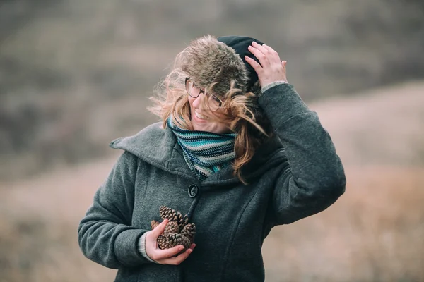 Девочка держит сосновые шишки — стоковое фото
