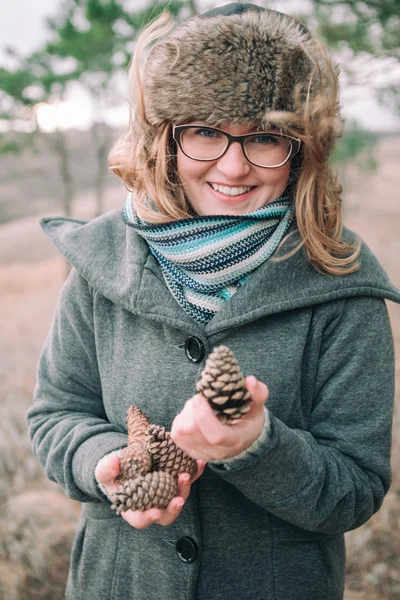 Girl holding pine cones — Stockfoto