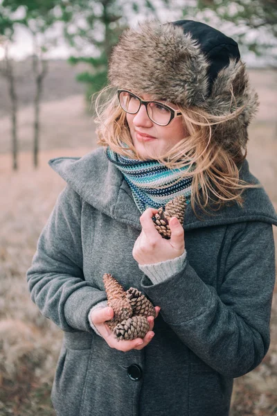 Girl holding pine cones — Stockfoto