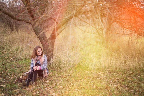 Junges Mädchen sitzt unter dem Baum — Stockfoto