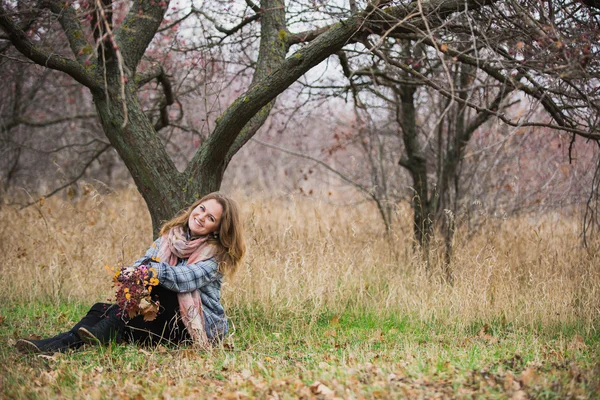 나무 아래에 앉아 어린 소녀 — 스톡 사진