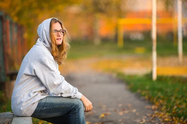 Mädchen sitzt auf Bank — Stockfoto