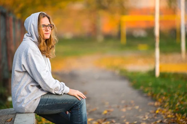 Mädchen sitzt auf Bank — Stockfoto