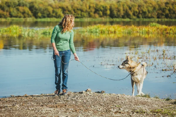 Mujer con perro cerca del lago — Foto de Stock