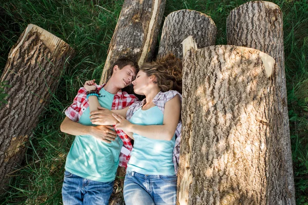 Par liggande på avverkade loggarna — Stockfoto