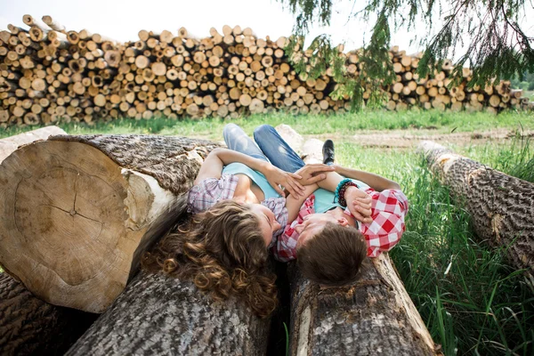 Par liggande på avverkade loggarna — Stockfoto