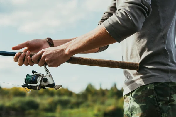 Homem segurando pólo de pesca — Fotografia de Stock