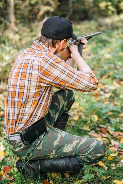 Hunter shooting in forest — Stock Photo, Image
