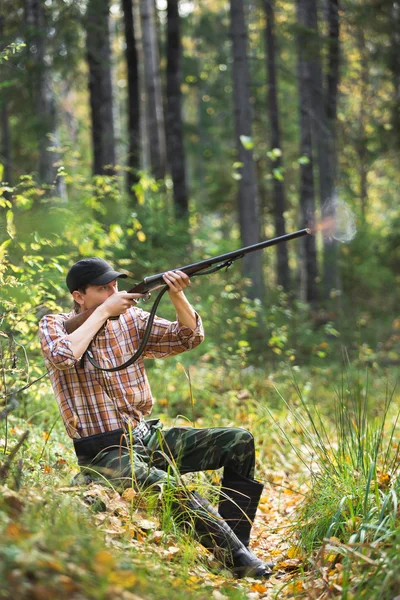 Hunter střílí v lese — Stock fotografie