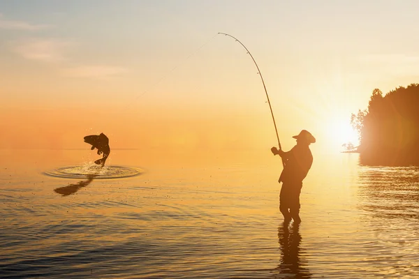 Рыбак на озере на закате — стоковое фото