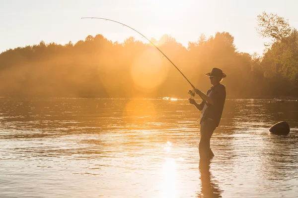 Gün batımında göl kenarında balıkçı — Stok fotoğraf