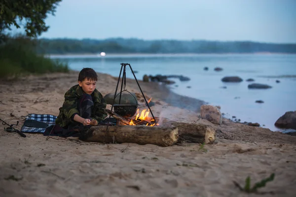 Anak laki-laki duduk di dekat api — Stok Foto