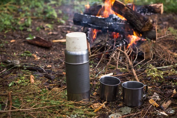 热水瓶和篝火附近的马克杯 — 图库照片