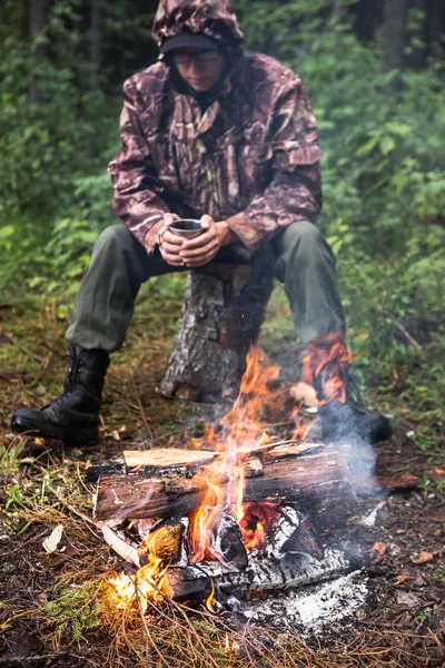 El hombre se calienta junto al fuego —  Fotos de Stock