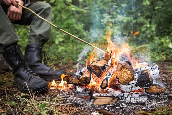 Homme rôtissant du pain sur le feu — Photo