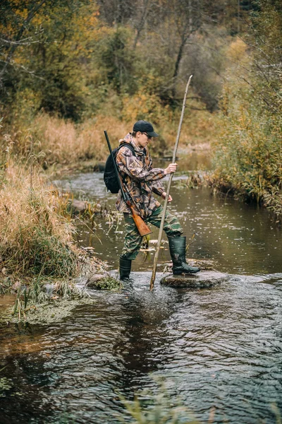 Man hunter passing stream — Stock Photo, Image