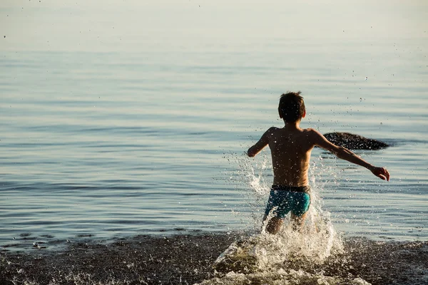 Мальчик бегает по воде — стоковое фото