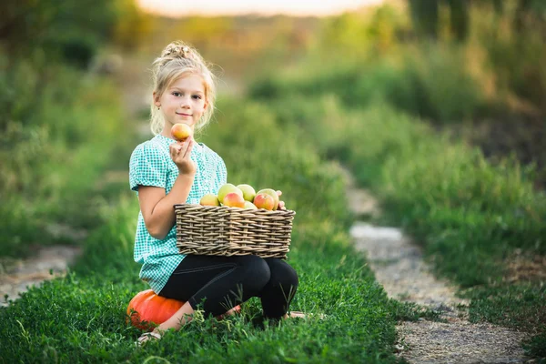 Mädchen mit einem Korb voller Äpfel — Stockfoto