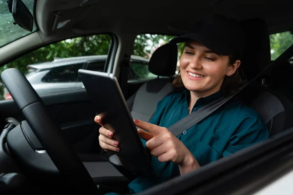 Mulher Mensageiro Sentado Carro Olhando Para Tablet Digital — Fotografia de Stock