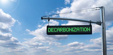 Road information board with text DECARBONIZATION on a background of blue sky. Carbon neutrality concept clipart