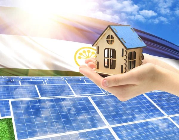 The photo with solar panels and a woman\'s palm holding a toy house shows the flag of Bashkortostan in the sun.