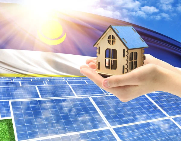 The photo with solar panels and a woman\'s palm holding a toy house shows the flag of Buryatia in the sun.