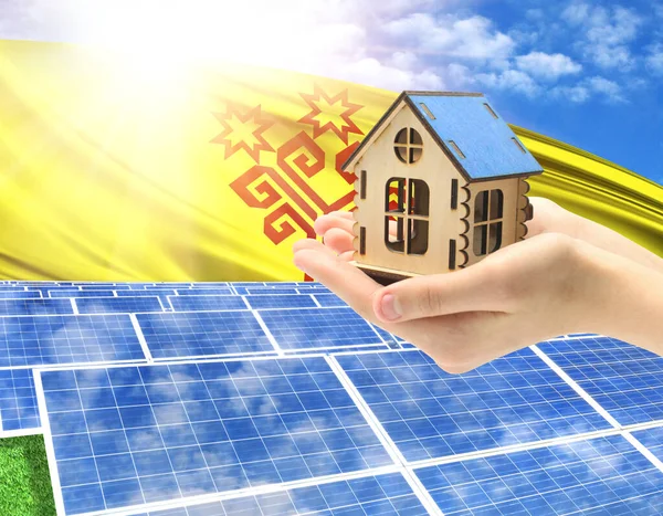 The photo with solar panels and a woman\'s palm holding a toy house shows the flag of Chuvashia in the sun.