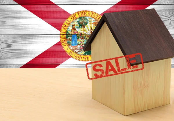 The concept sale of apartments, of real estate mortgages, citizenship and accommodation, as well as investment in a future home. State of Florida flag on wooden background.