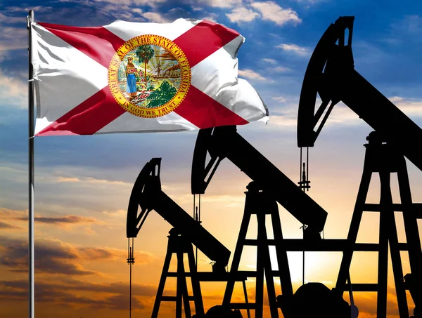 Oil rigs against the backdrop of the colorful sky and a flagpole with the flag State of Florida. The concept of oil production, minerals, development of new deposits.