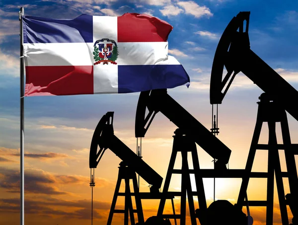 Oil rigs against the backdrop of the colorful sky and a flagpole with the flag of Dominican Republic. The concept of oil production, minerals, development of new deposits.
