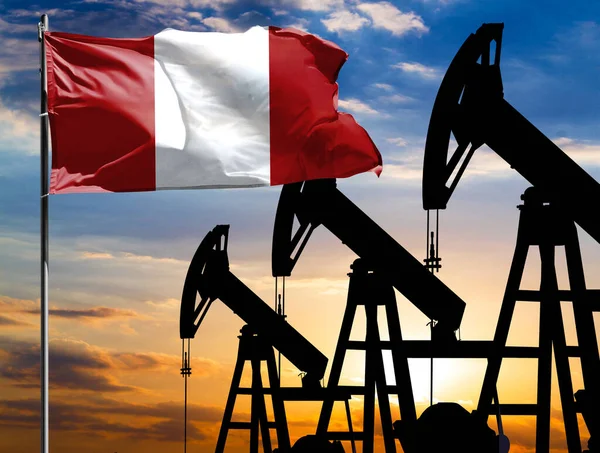 Oil rigs against the backdrop of the colorful sky and a flagpole with the flag of Peru. The concept of oil production, minerals, development of new deposits.