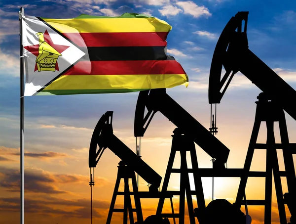 Oil rigs against the backdrop of the colorful sky and a flagpole with the flag of Zimbabwe. The concept of oil production, minerals, development of new deposits.