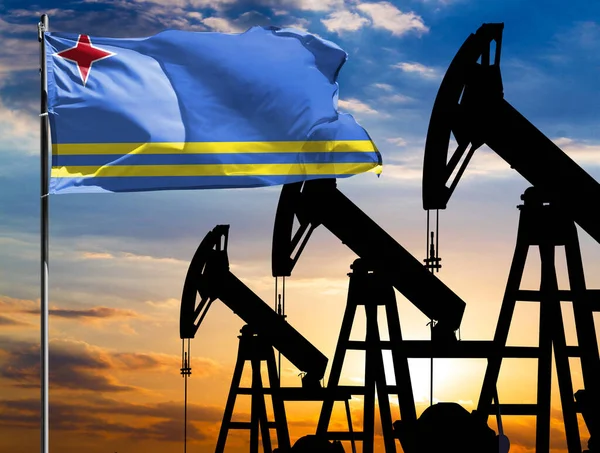 Oil rigs against the backdrop of the colorful sky and a flagpole with the flag of Aruba. The concept of oil production, minerals, development of new deposits.