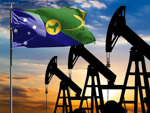 Oil rigs against the backdrop of the colorful sky and a flagpole with the flag of Christmas Island. The concept of oil production, minerals, development of new deposits.