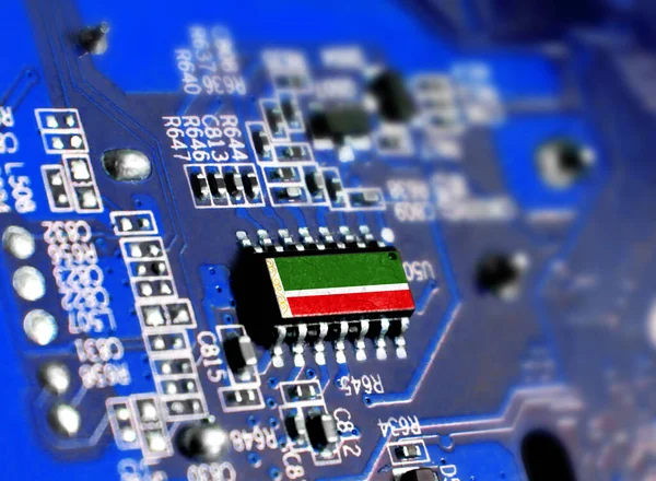 Electronic board with embedded microchip and shown flag of Chechen Republic. The concept of modern computer technologies.
