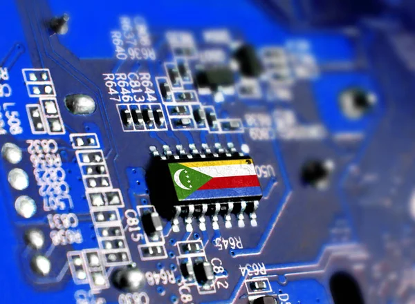 Electronic board with embedded microchip and shown flag of Comoros. The concept of modern computer technologies.